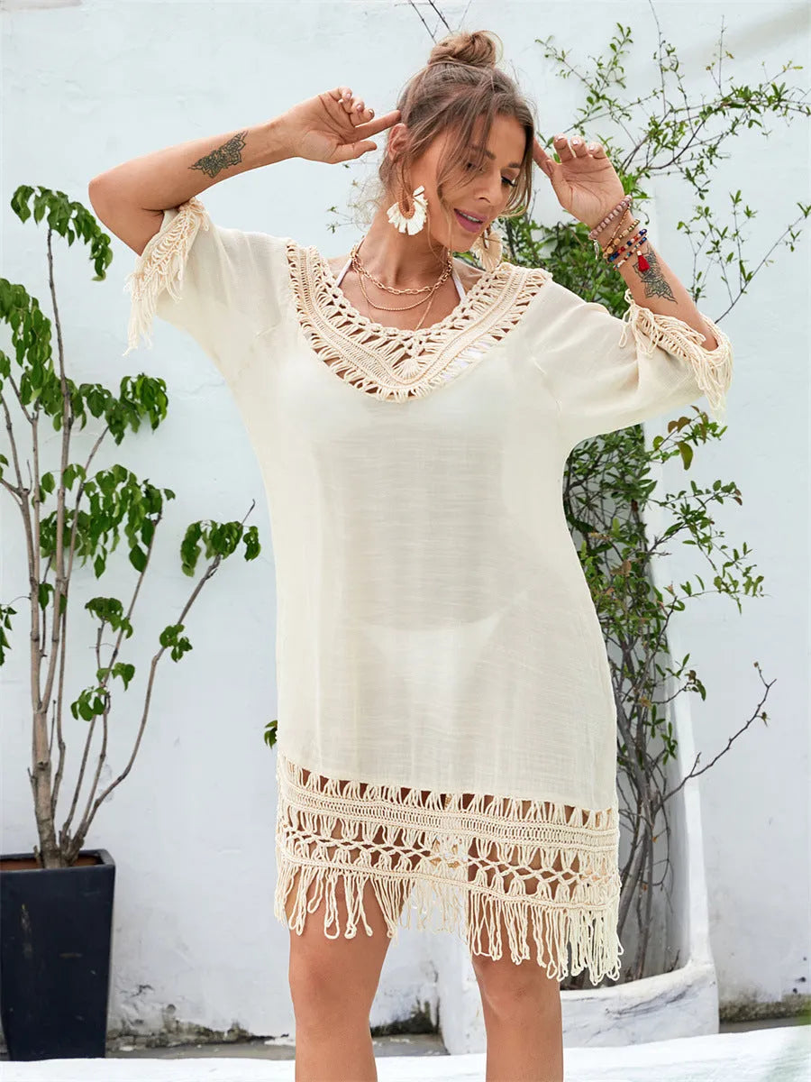 Apricot coloured hand-crocheted acrylic beach dress for women on a hanger.