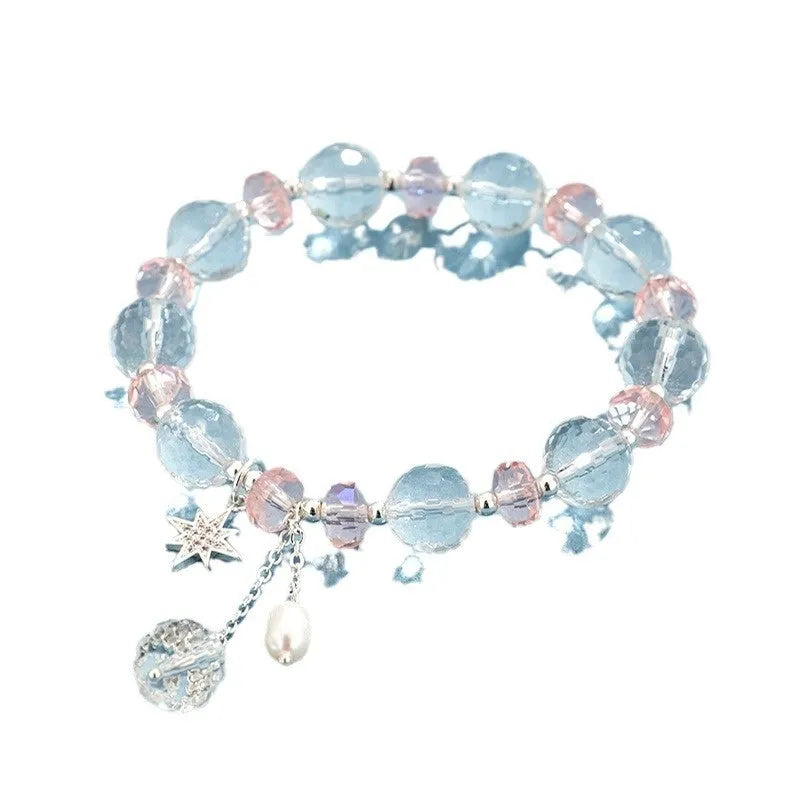 Women's white crystal bracelet with diamond shapes and lucky cat charm on wrist