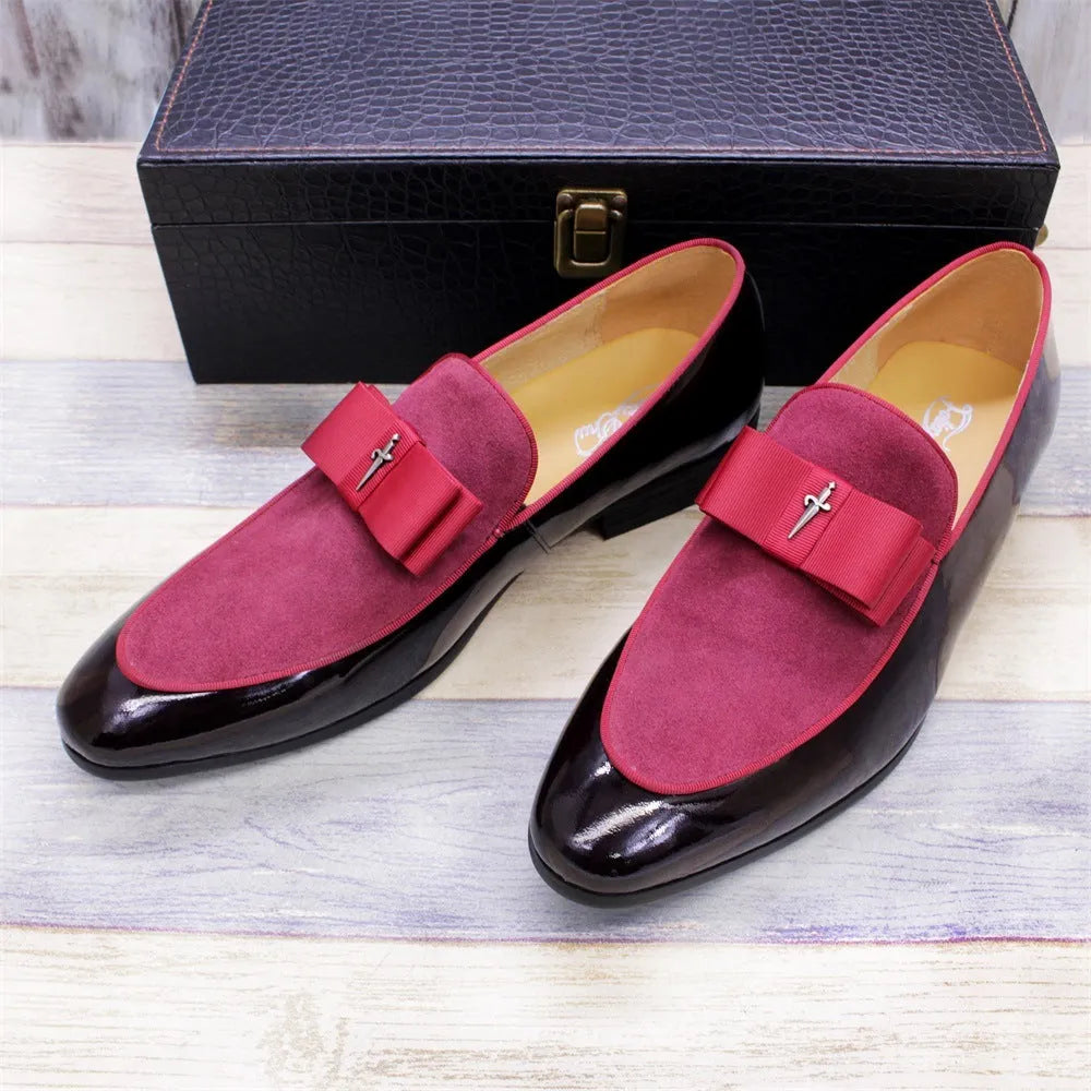 Men's black patent leather shoes with a gold tassel detail on a rubber sole.