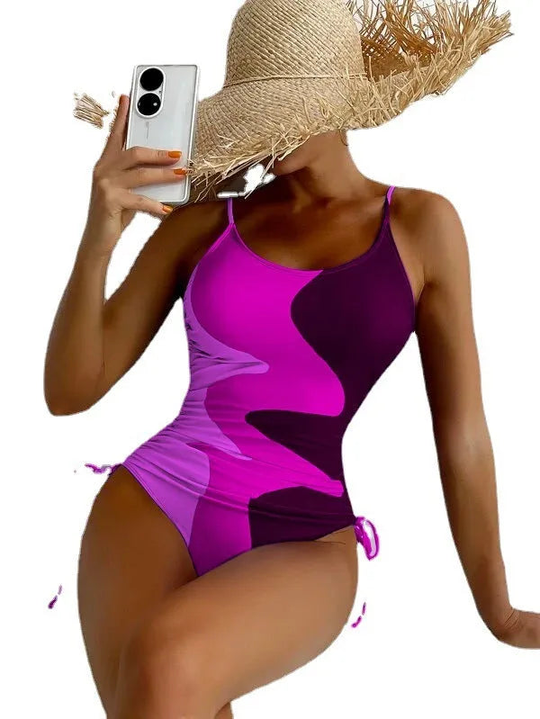 Women's sleeveless one-piece swimsuit in blue with striped pattern, backless design.