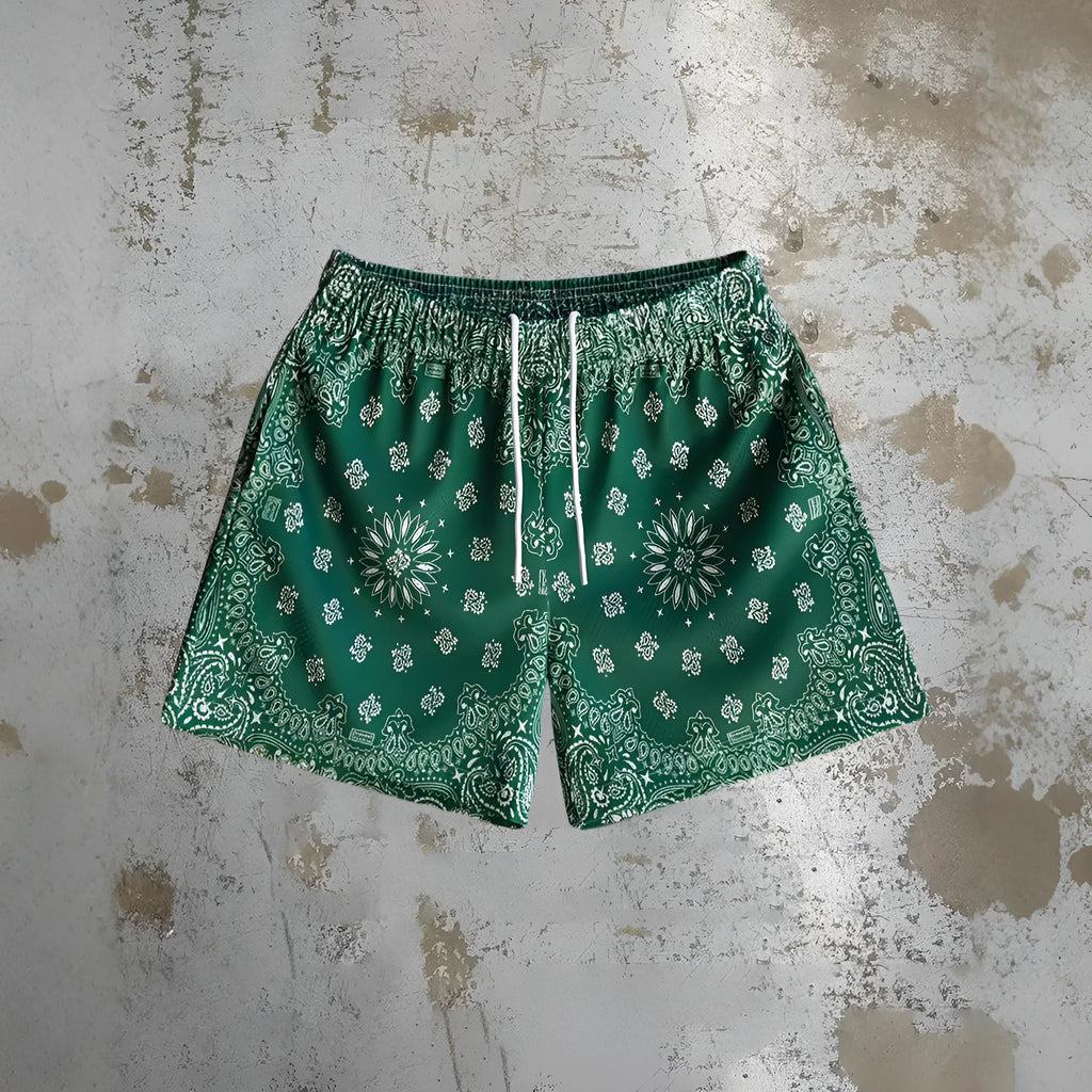 Man wearing loose-fitting digital print beach shorts in a contemporary colour, showing the elastic waistband and quick-dry milk silk fabric.