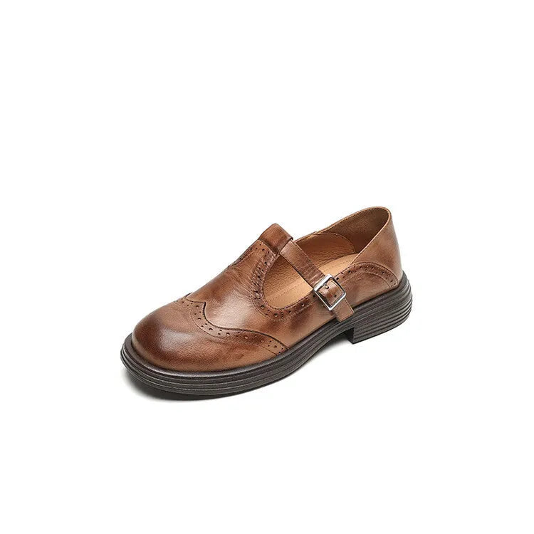 Women's black British style leather flat shoe with round toe and slip-on design on a neutral background.