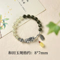 Handmade women's retro bracelet with a natural Hetian jade bead and pure silver coin charm on an adjustable chain.
