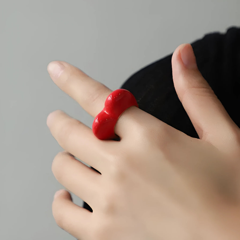 Heart-shaped zinc alloy ring with colourful three-dimensional enamel details on a neutral background.