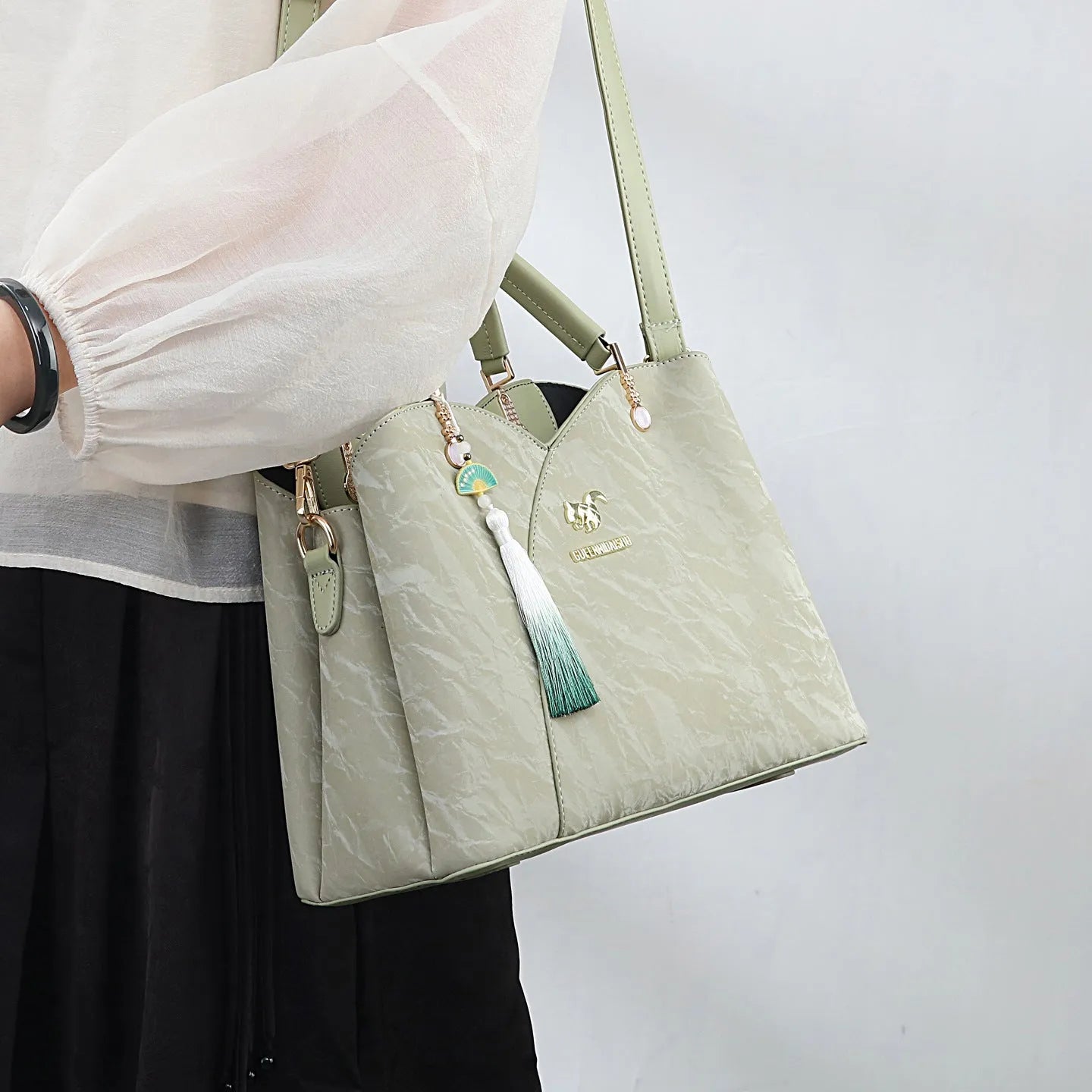 Women's black PU leather messenger bag with sewing thread detail and adjustable shoulder strap