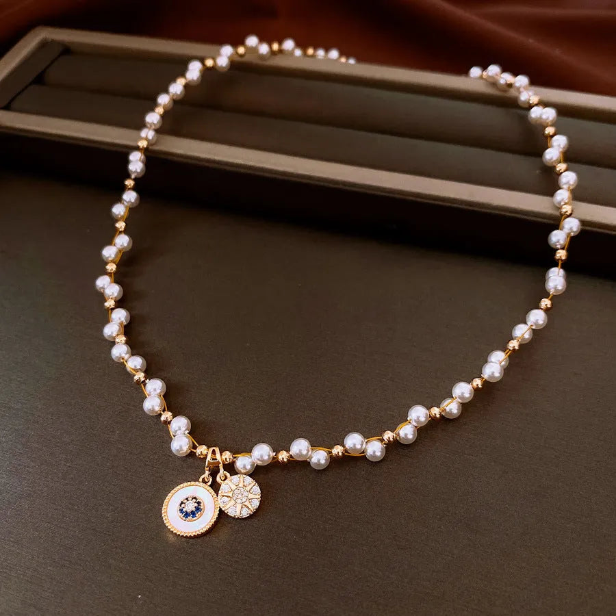 Gold electroplated women's clavicle necklace with round zircon pearl pendant on white background