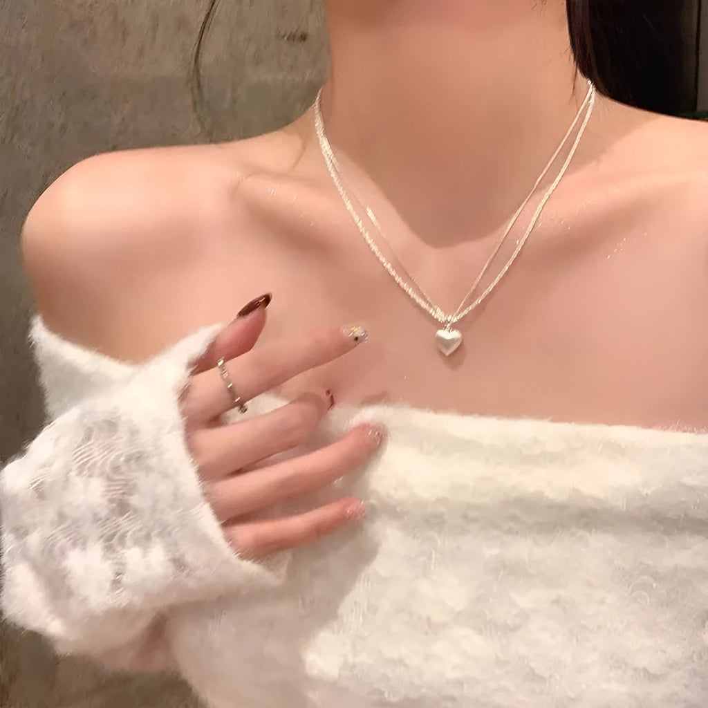 Women's brushed silver double-layer heart pendant necklace on an adjustable chain.