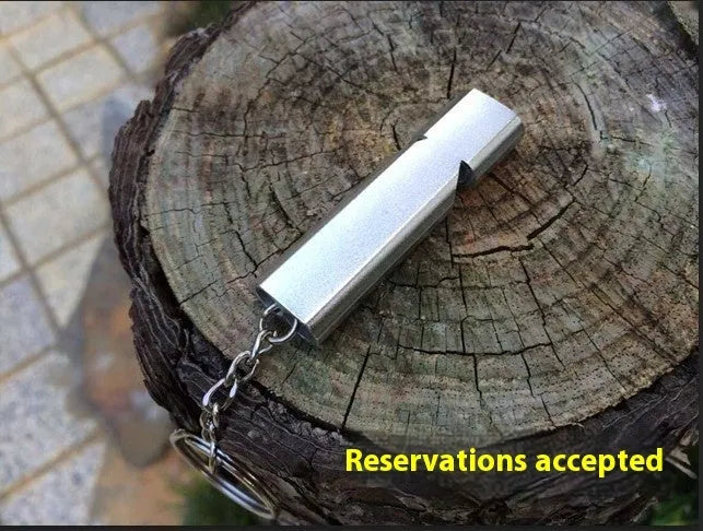 Silver or gold coloured aluminium alloy double hole outdoor survival whistle.