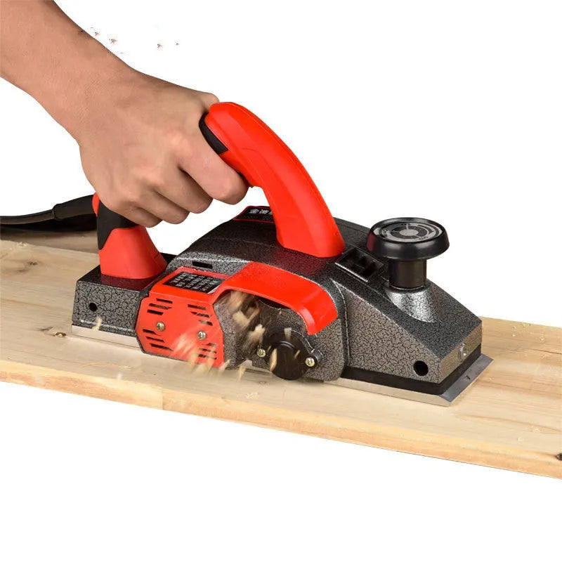 Red desktop electric wood planer with aluminium body showing 82mm planing width