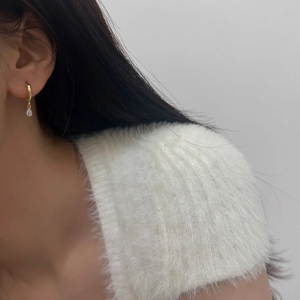 A women's zircon jewellery set showing a geometric meteor shower necklace, matching earrings, and an anklet on a white background.