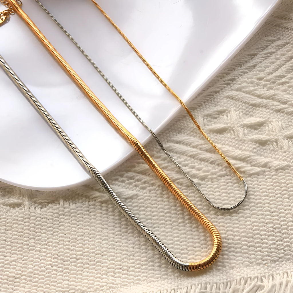 Gold-colour women's snake bones chain necklace with geometric alloy pendant, 3mm wide.