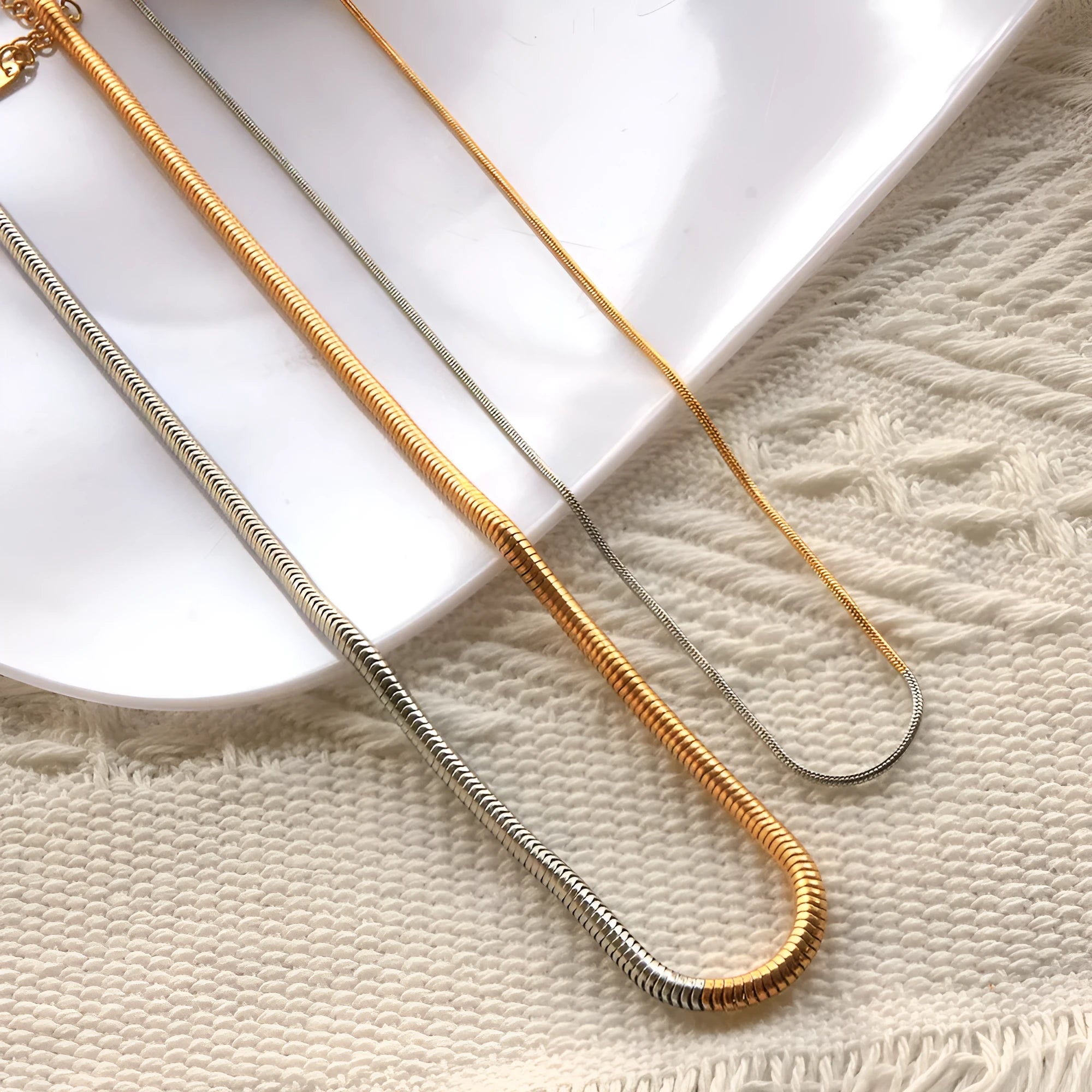 Gold-colour women's snake bones chain necklace with geometric alloy pendant, 3mm wide.