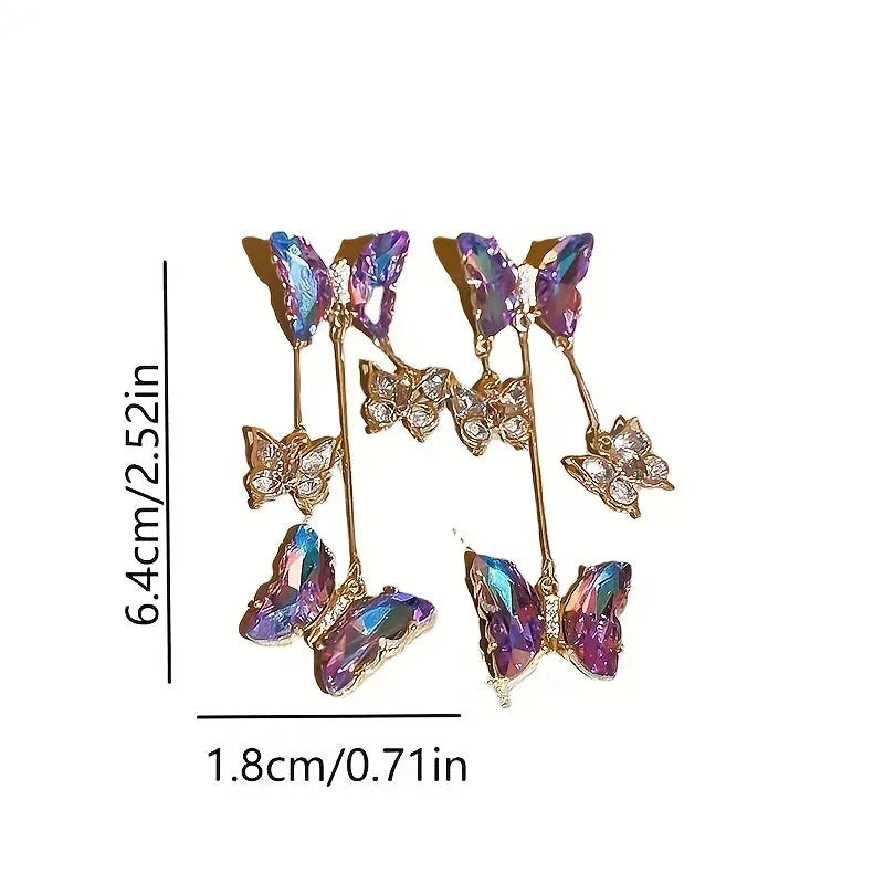 A pair of blue purple butterfly tassel drop earrings with crystal flowers and silver needle details on alloy.