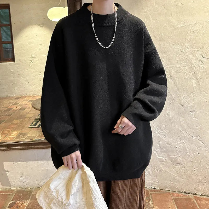 Man wearing a loose fit, solid colour round neck pullover sweater.