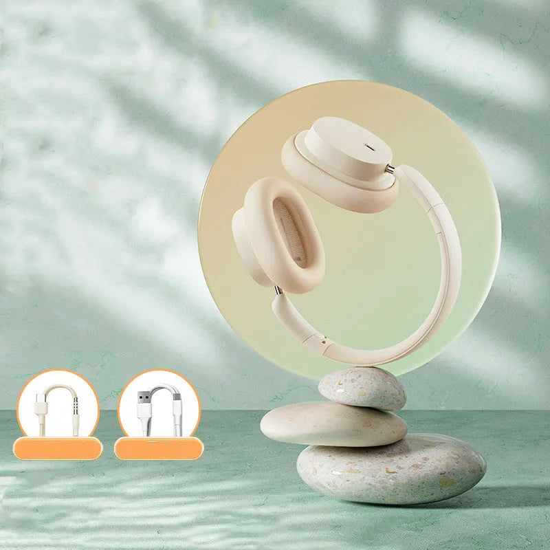 Beige and grey Bluetooth over-ear headphones with a Type-C charging cable on a table.