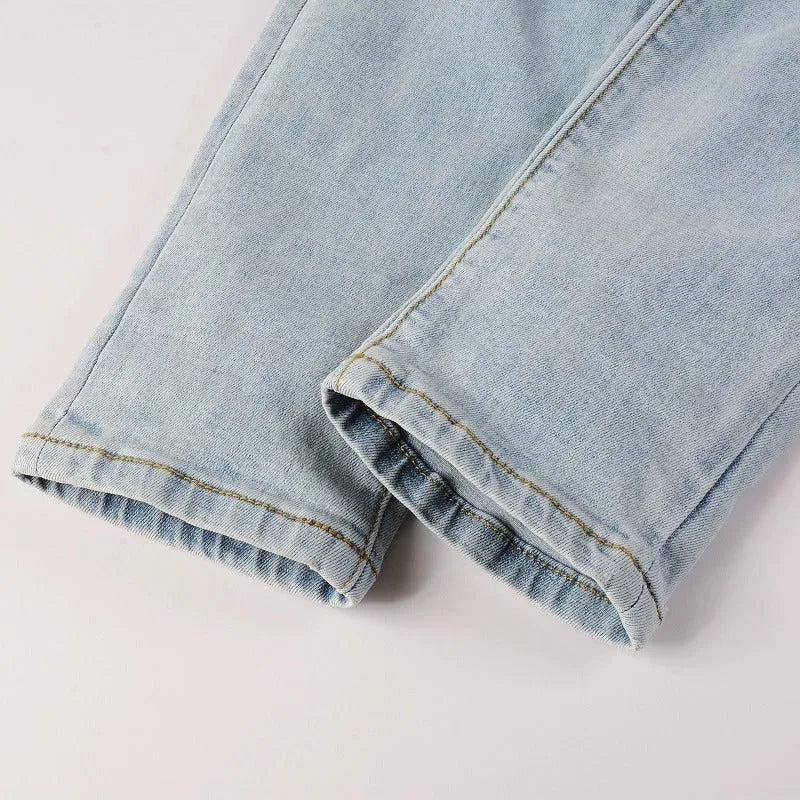 Light blue slim fit stretch men's jeans with distressed details and diamond patch pocket
