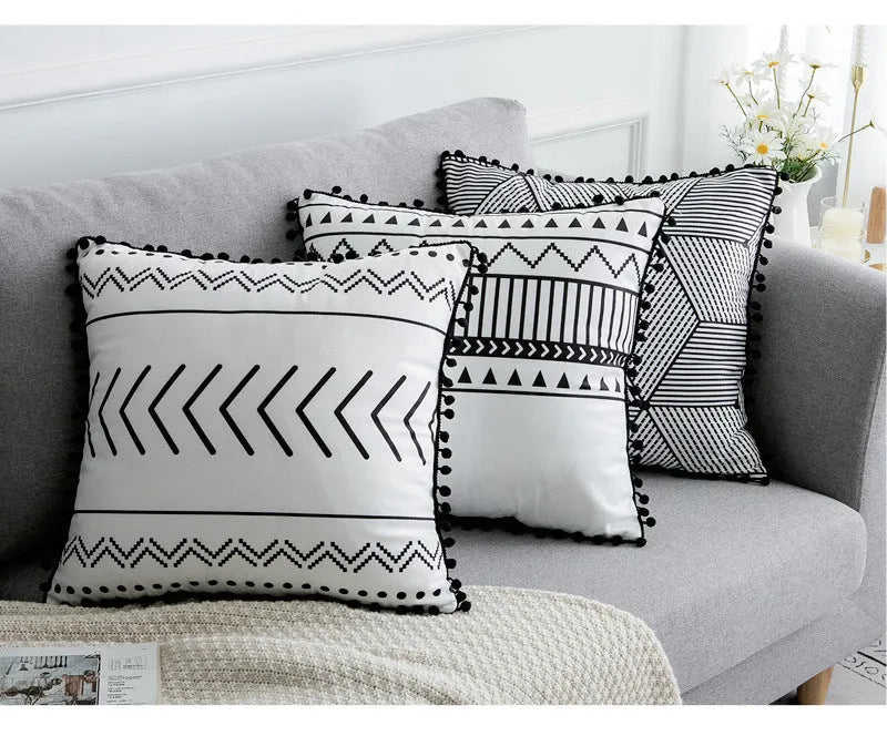 Bohemian national style throw pillow cushion cover in light grey on a sofa.