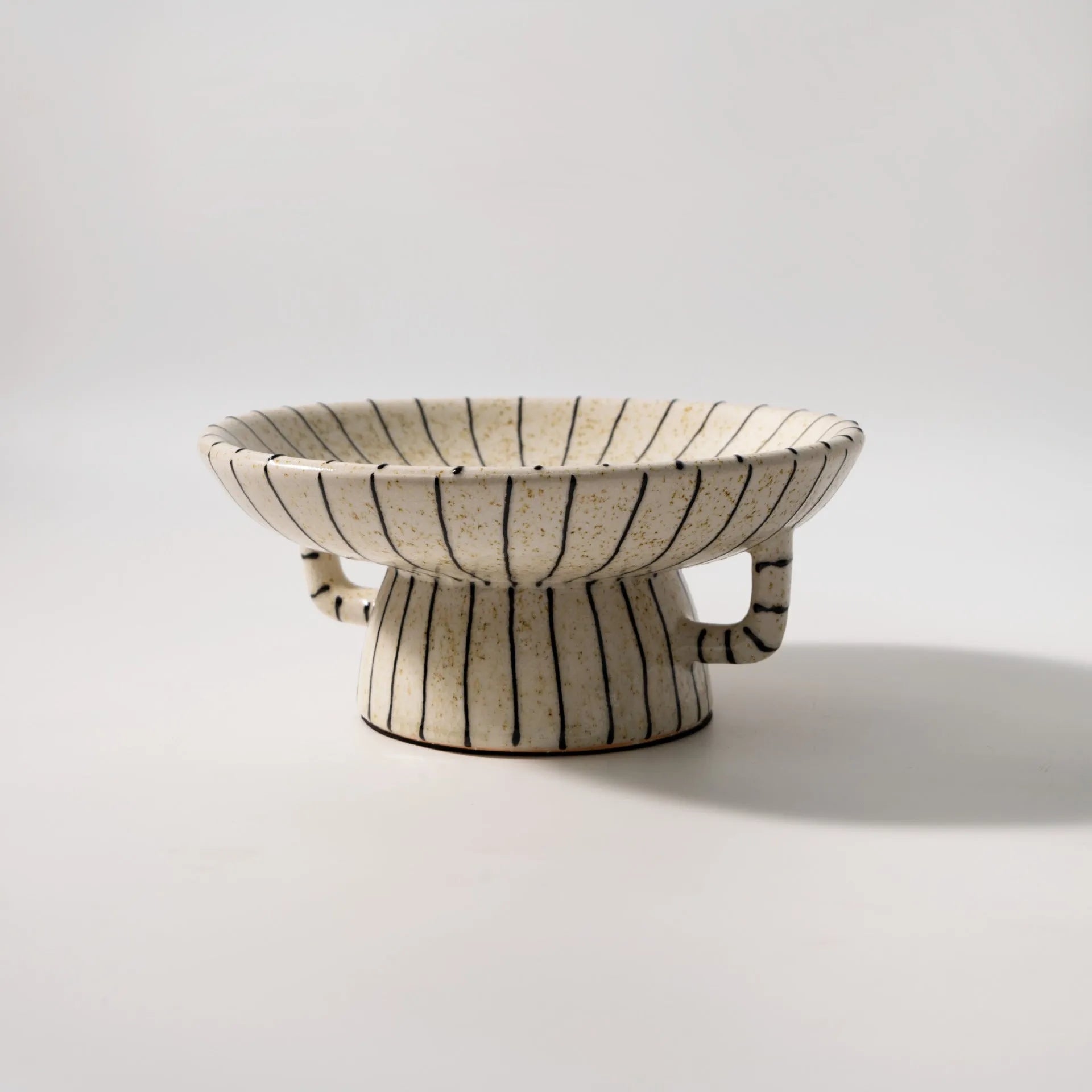 Black and white striped retro style synthetic resin fruit plate on a wooden surface.