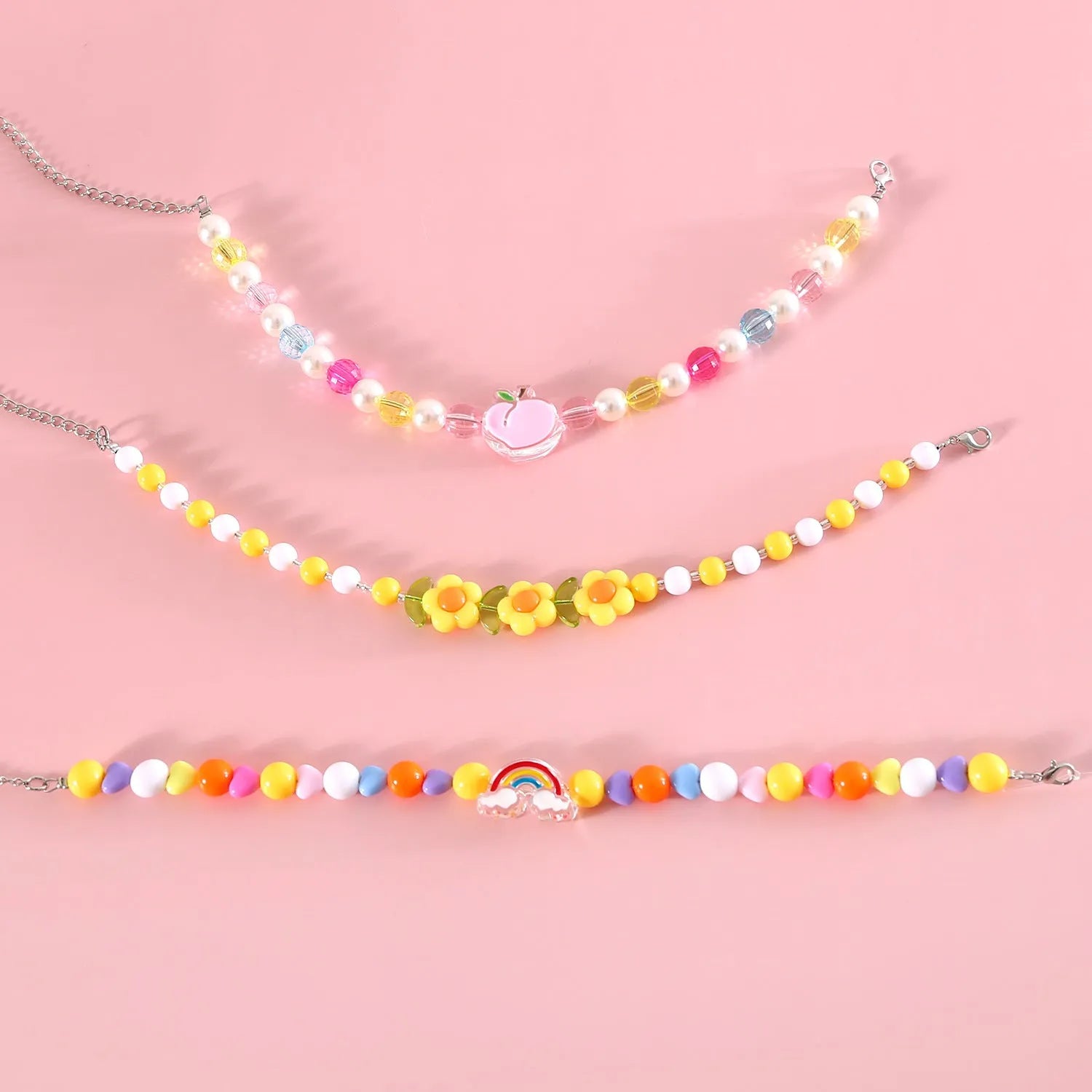 Colourful plastic bead cat necklace showing small flower, rainbow, and peach pattern options with adjustable sizing