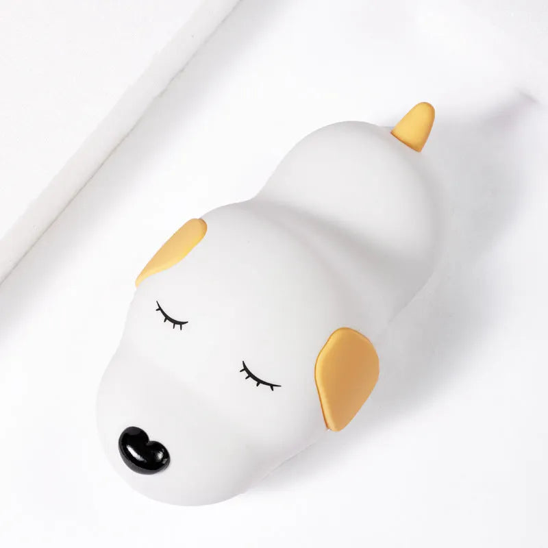 Small two-tone cartoon dog shaped silicone night lamp with USB charging port.