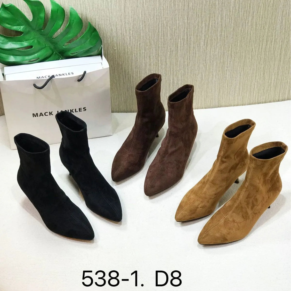 Black pointed toe women's ankle boots with a stiletto heel and mid-calf sock length on a white background