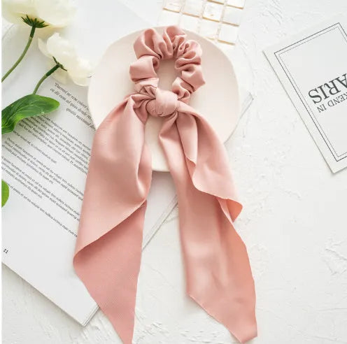 Women's cloth ribbon hair tie in large intestine ring shape with floral detail on dark green background