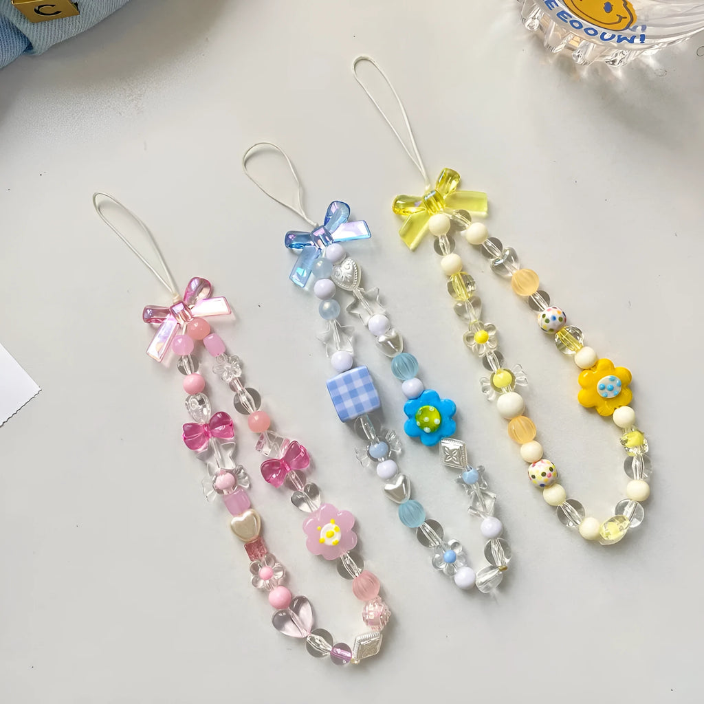 Colourful beaded mobile phone lanyard with a blue resin flower charm on a hand strap.