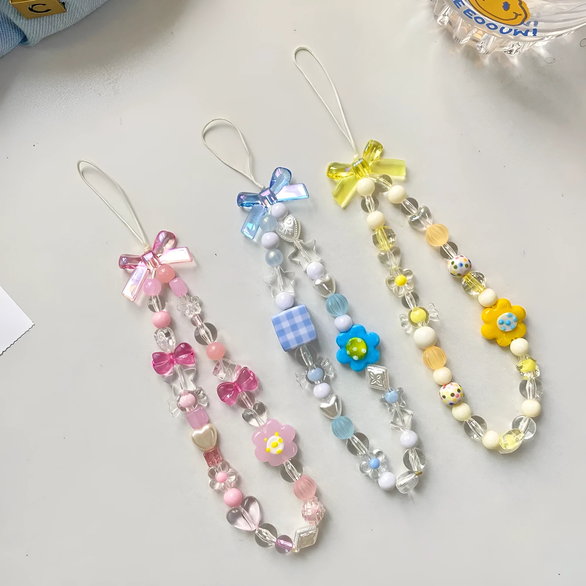 Colourful beaded mobile phone lanyard with a blue resin flower charm on a hand strap.