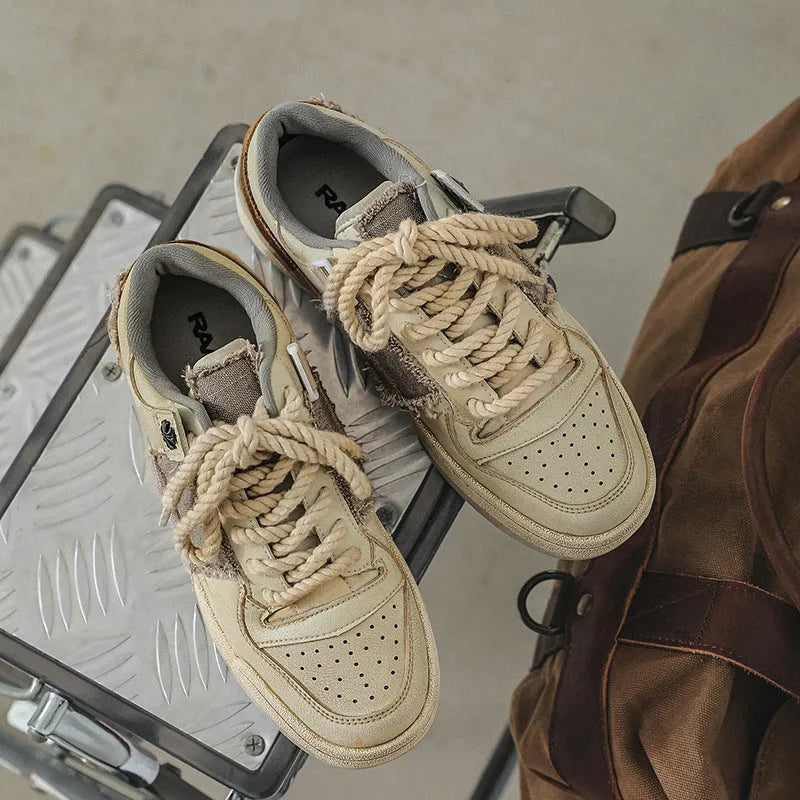 Beige low-top vintage skateboard shoes with round toe and rubber sole on a white background