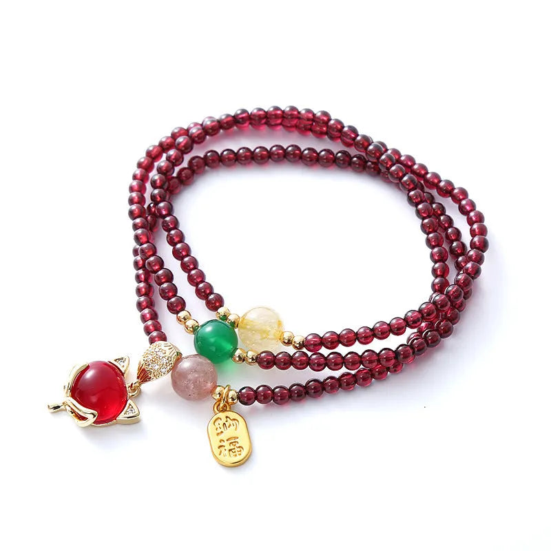 Purplish red garnet fox charm on an adjustable rope bracelet for women.