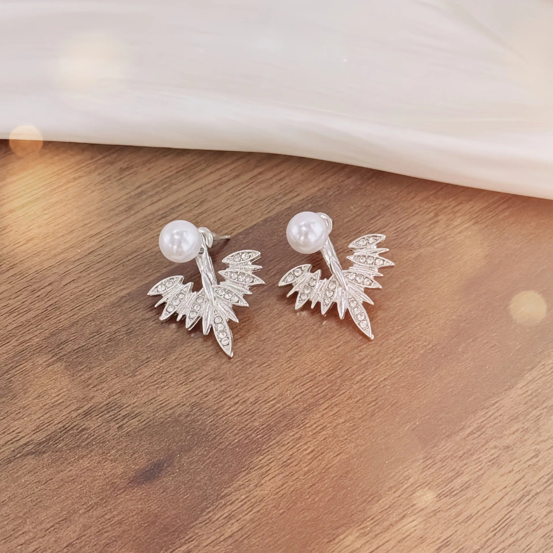 Silver ladies backward-hanging wing pearl earrings with diamond setting on alloy base