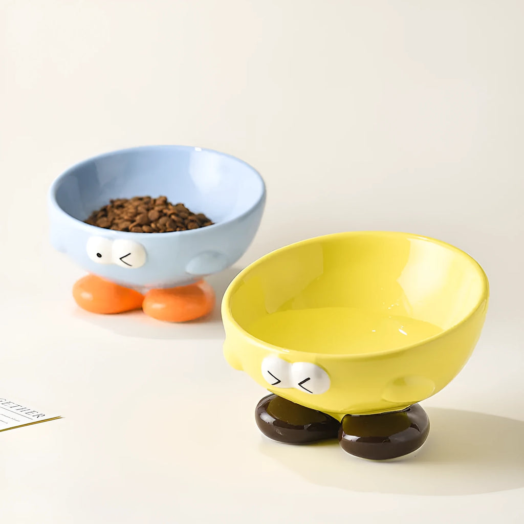 Blue ceramic oblique pet bowl with tall sides and a cute expression print for cervical spine support.