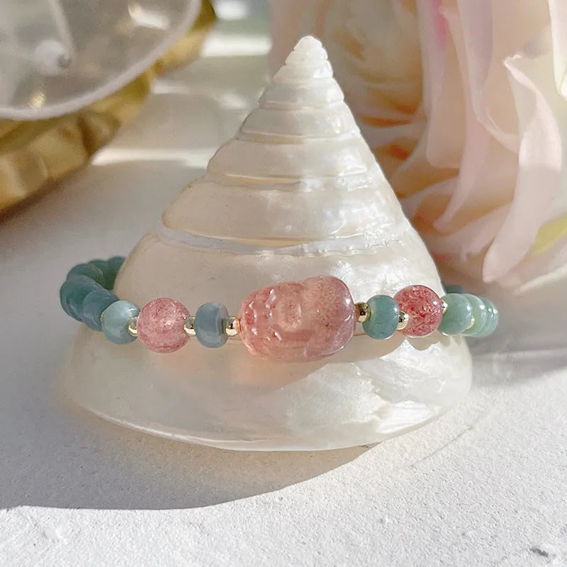 Women's jade bracelet with gourd shape, peace buckle charm, and strawberry quartz details in natural blue colours