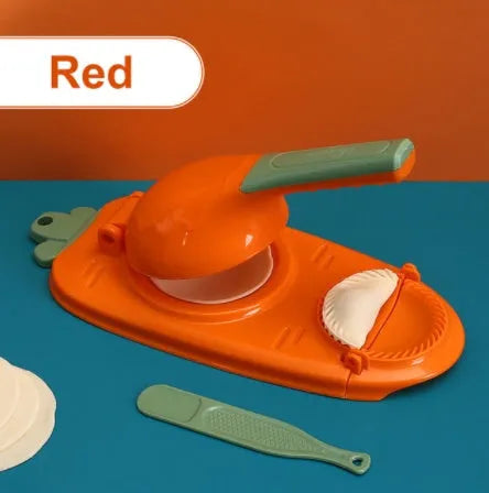 Orange and white plastic manual dumpling press tool with ergonomic handle on a kitchen worktop.