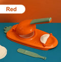 Orange and white plastic manual dumpling press tool with ergonomic handle on a kitchen worktop.