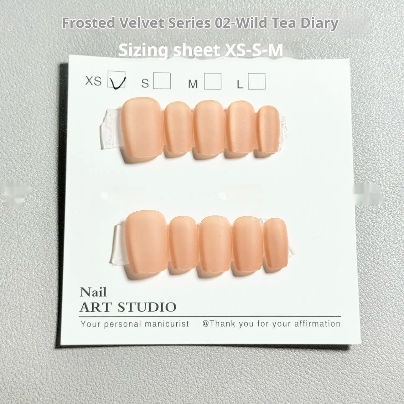Set of velvet frosted cat's eye aurora effect false nails in short ladder sizes XS, S, and M on a white background.