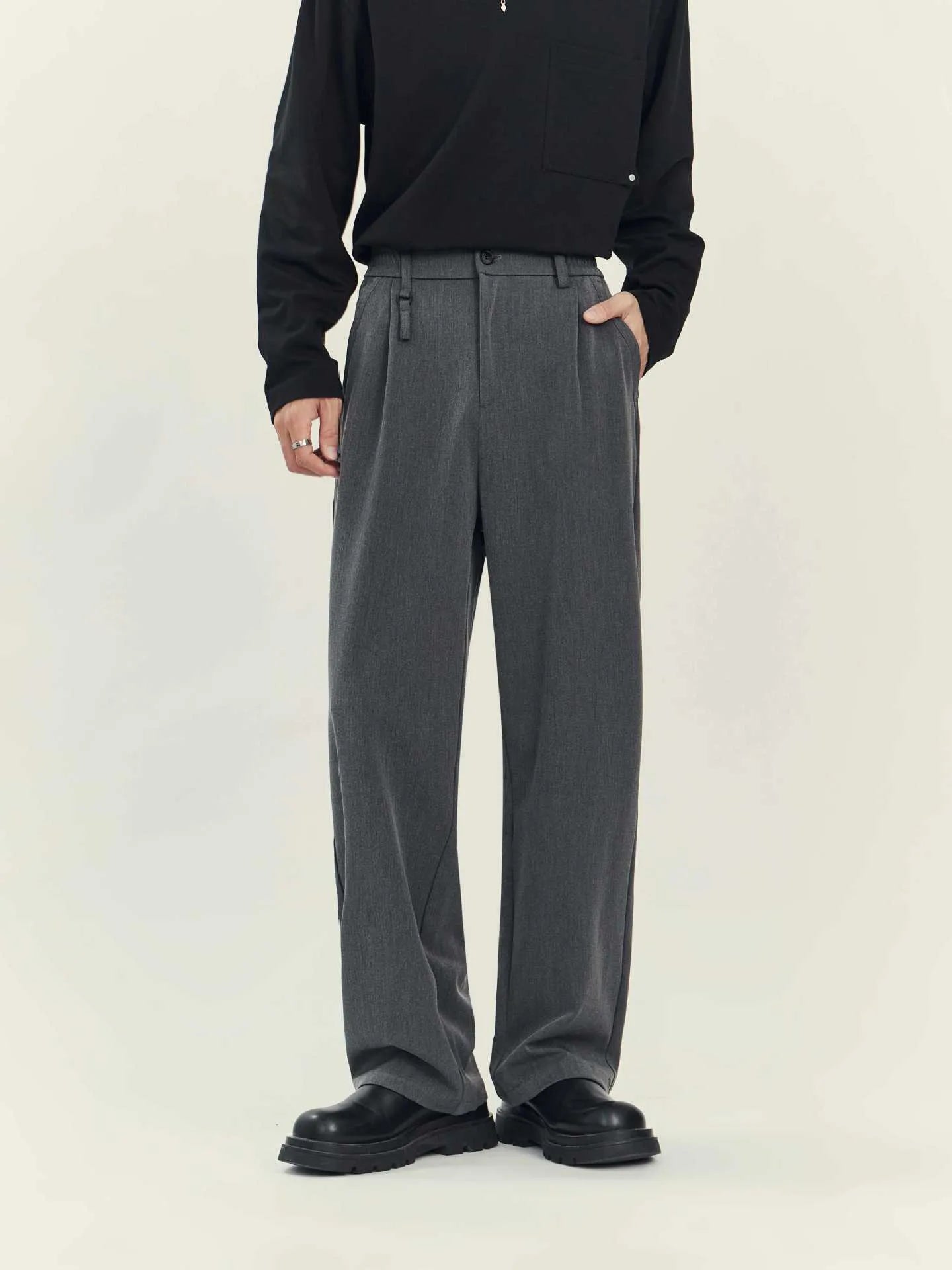 Man wearing black straight-leg business casual trousers with a draping design, made from a polyester blend fabric.