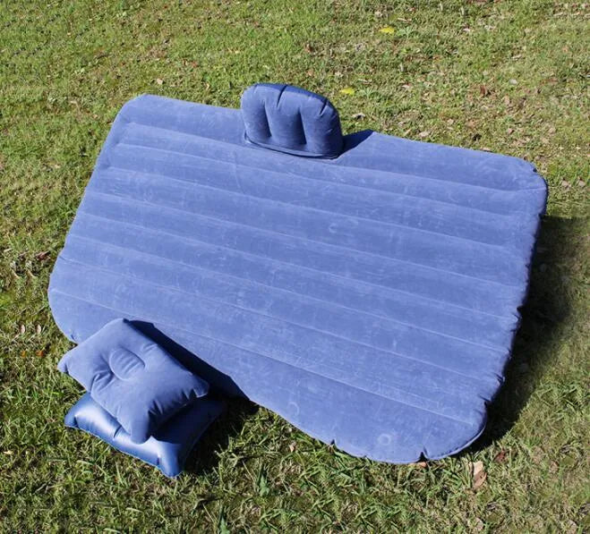 Universal inflatable car air mattress with flocked surface and pillows inside a vehicle.