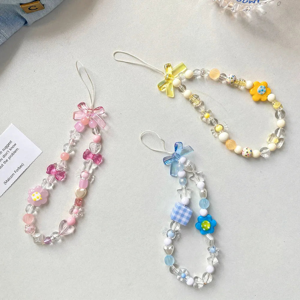 Colourful beaded mobile phone lanyard with a blue resin flower charm on a hand strap.