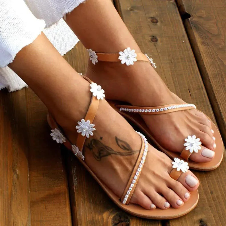 Brown women's flat Roman-style sandals with floral design on the artificial PU upper.