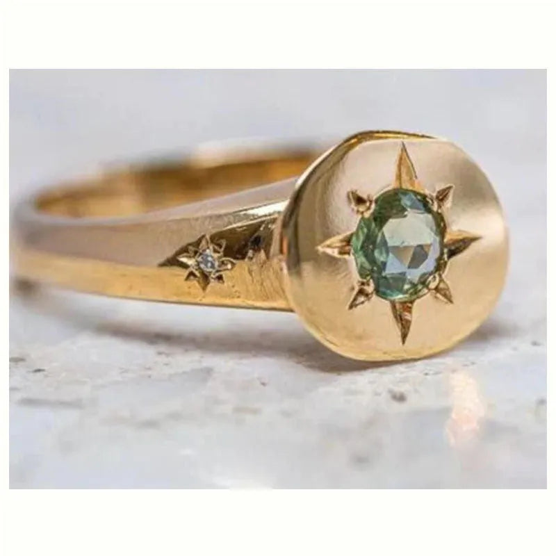 Gold-colour adjustable ring with an oval-shaped star design and central zircon stone.