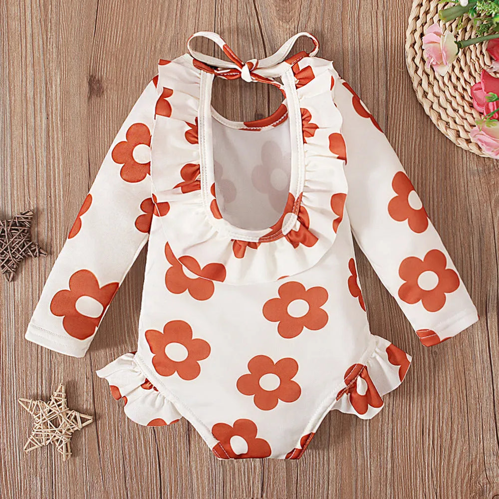 Girl's floral print swimsuit with crew neck and open back in orange red colour.