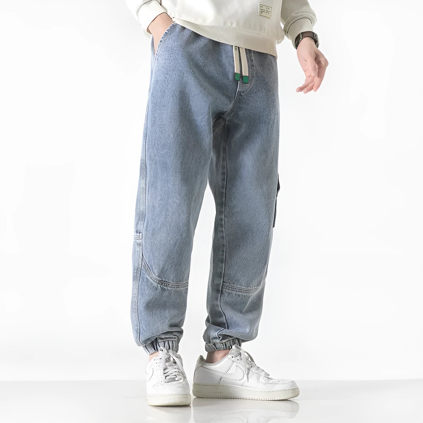 Men's loose-fit tapered cotton trousers shown in black, blue, and grey colour options.