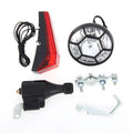 Silver bicycle dynamo generator light kit mounted on a bicycle frame with headlight and taillight.