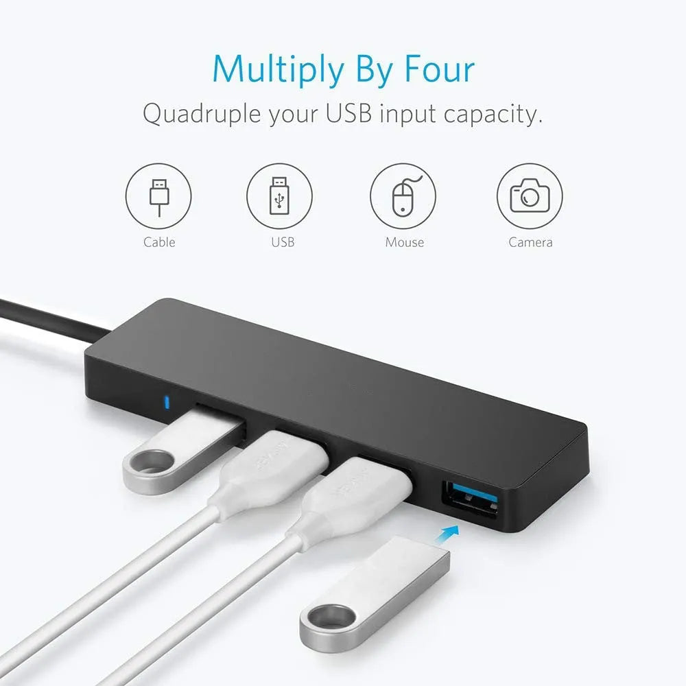 Black USB 3.0 hub with four ports and a 30 cm attached cable on a desk.