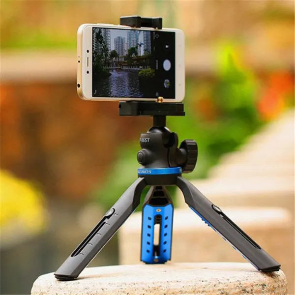 Black desktop tripod holding an iPhone, made from aluminium alloy and plastic, on a wooden table.