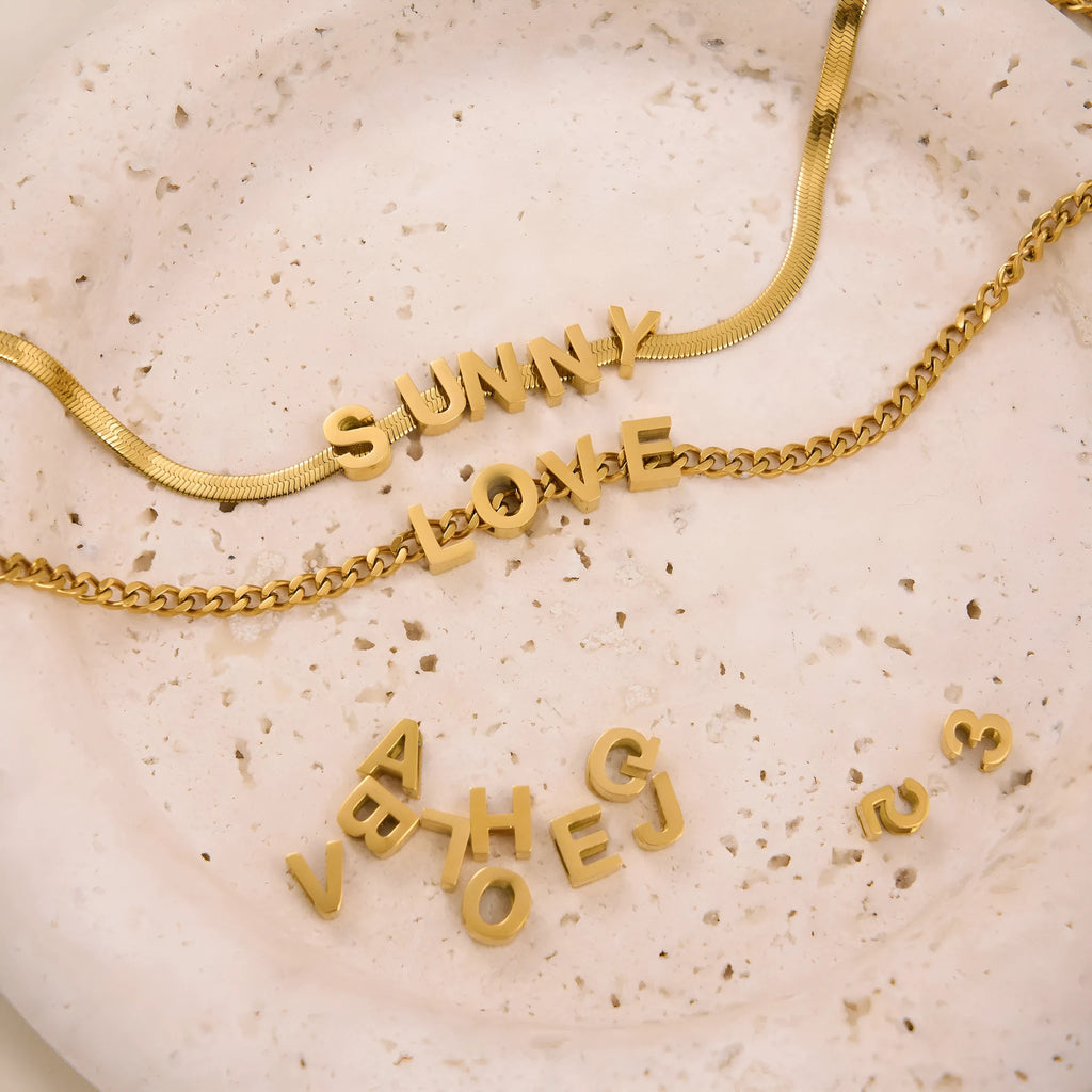 Gold electroplated titanium steel necklace with a single letter A pendant on a 40.5cm blade chain.