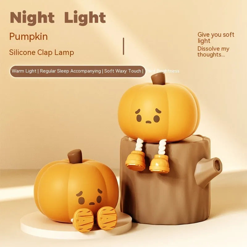 Soft orange silicone pumpkin-shaped night light with a warm glow on a bedside table.