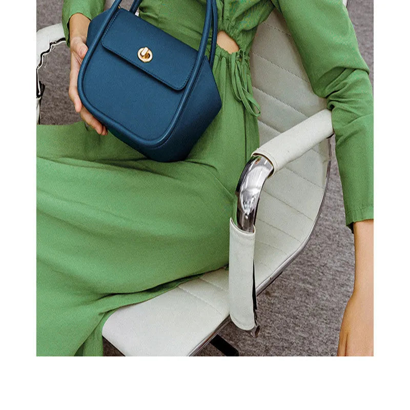 Women's leather wing tote bag in cow leather with a cross-body strap and buckle detail.