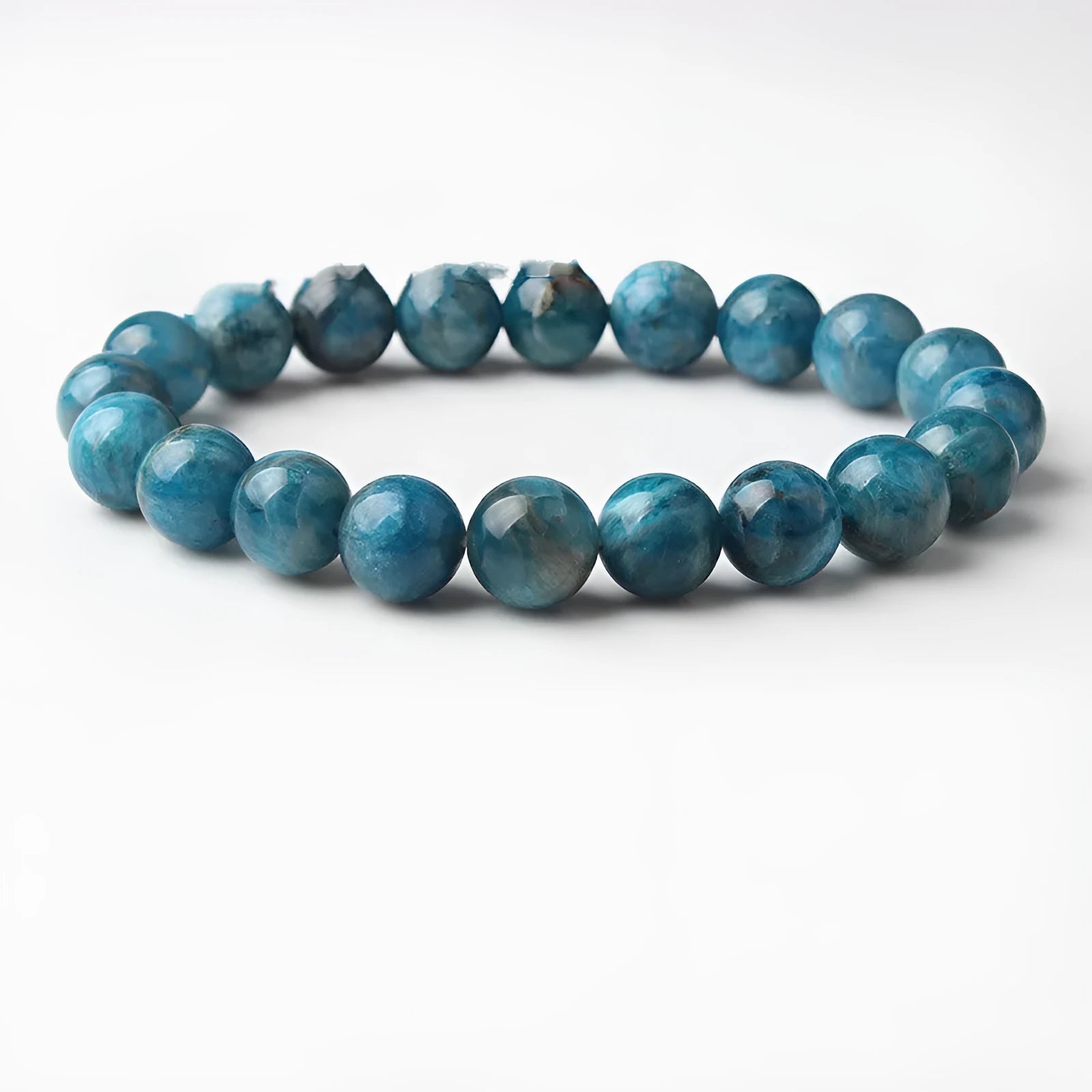 Natural blue apatite elastic beaded bracelet with polished round beads, unisex design, shown on a neutral background